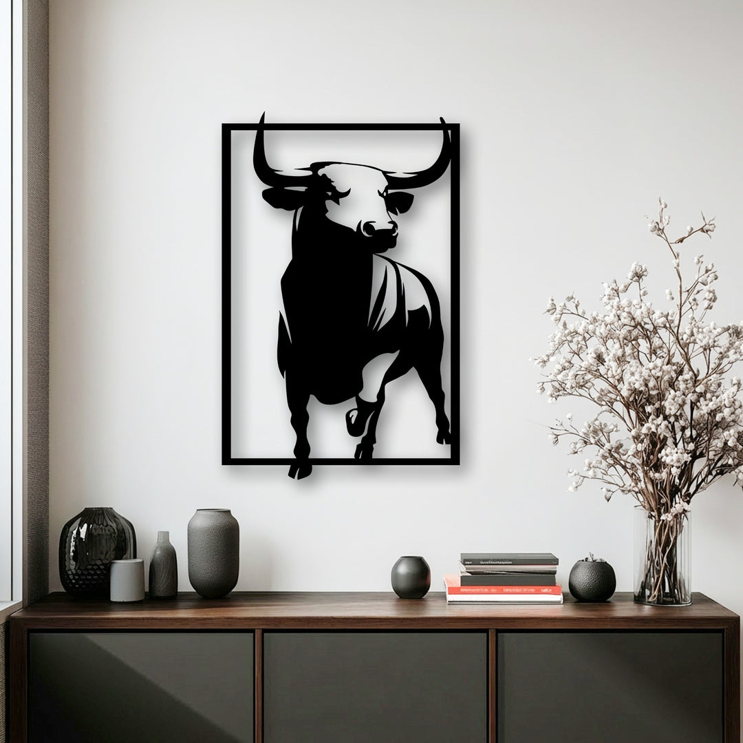 The background features a crisp white wall above a dark console table displaying vases and white flowers, framing the bull decoration wall art.