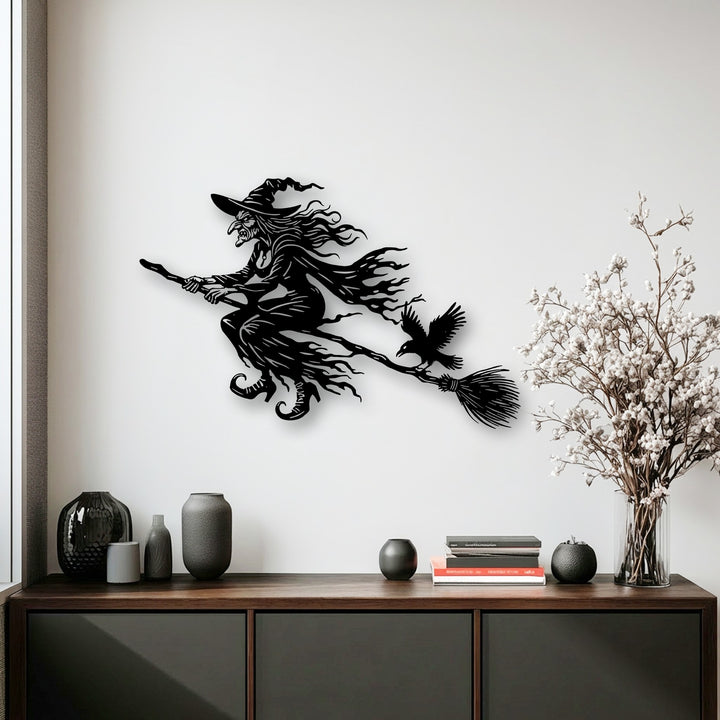 With low color saturation, the dark flying witch metal wall decor sharply contrasts a light wall, creating a striking Halloween scene.
