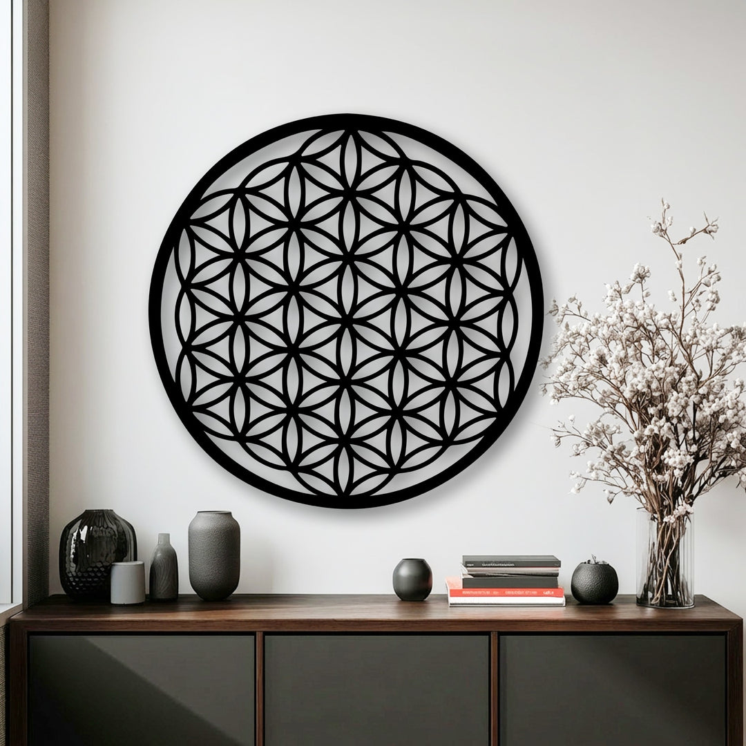 The striking black Flower of Life decorative metal art, featuring an intricate sacred geometry circle design, is the focal point on a crisp white wall.