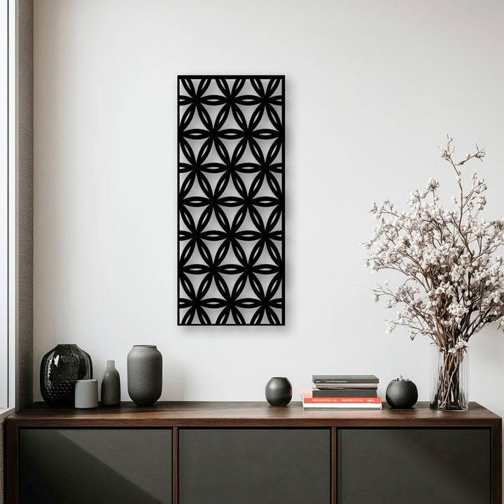 The brightest area highlights the striking geometric floral pattern of the metal decoration wall art against a clean white wall.