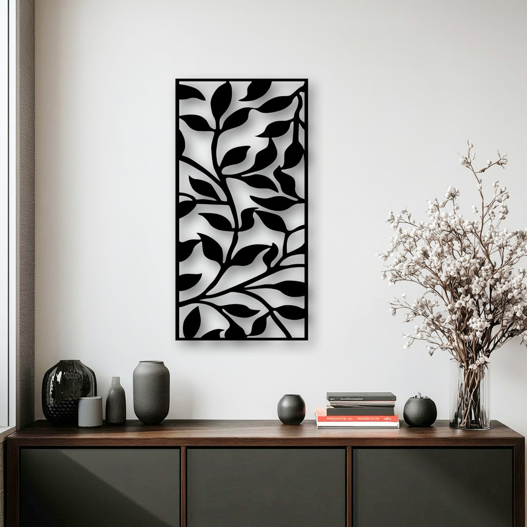 The darkest area features the intricate, jet-black abstract leaf pattern, a unique metal wall art piece, contrasting against a bright wall.