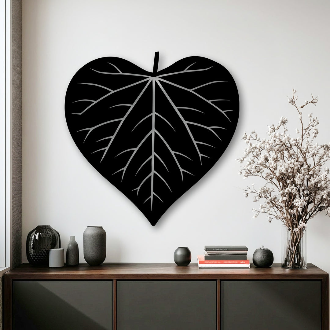 The smooth, defined edges and borders of the striking black heart-shaped leaf silhouette metal artwork are prominently featured.