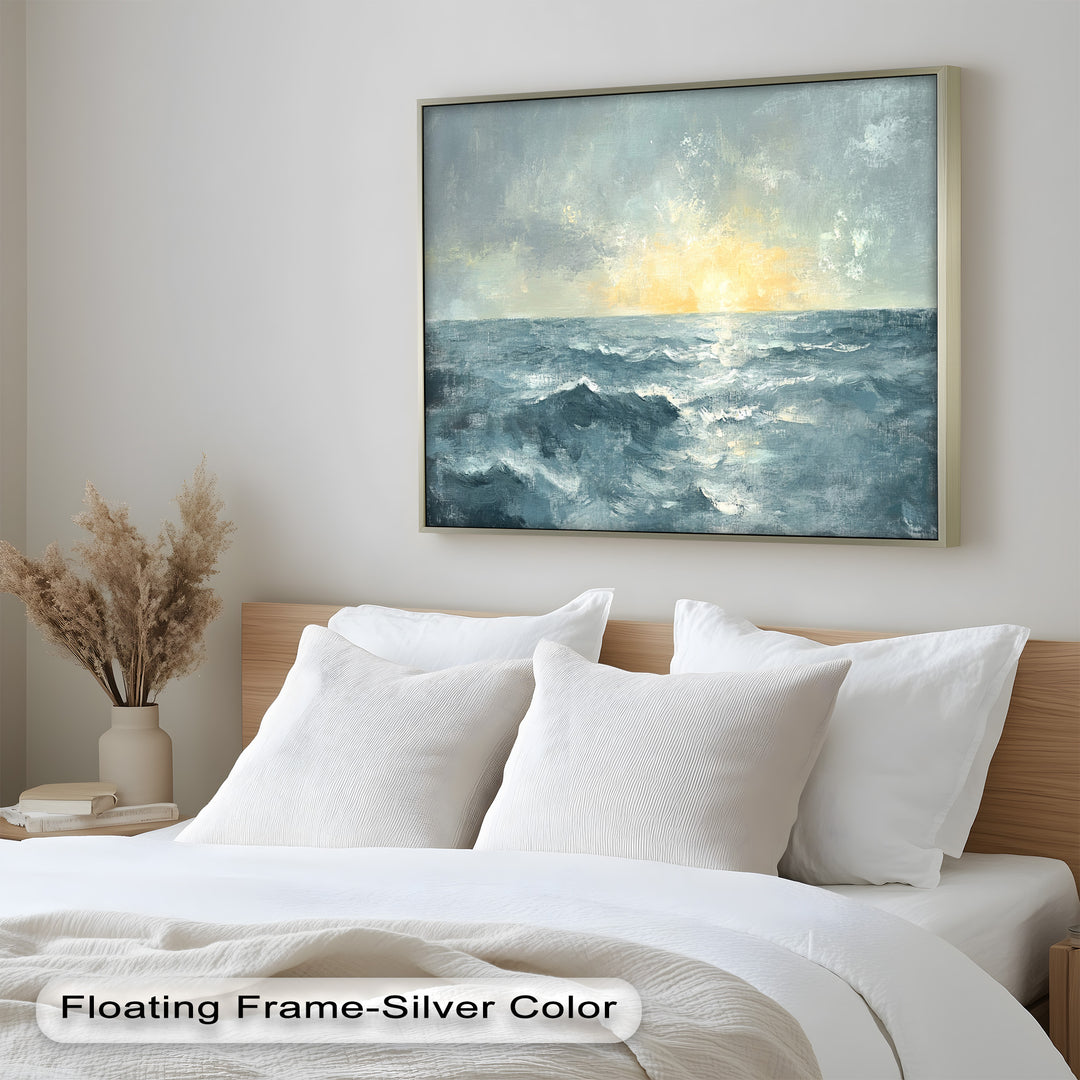 This serene ocean sunset painting, displayed in a white deep frame, brings a calming coastal atmosphere to the room with its soft blue waves and glowing golden horizon.
