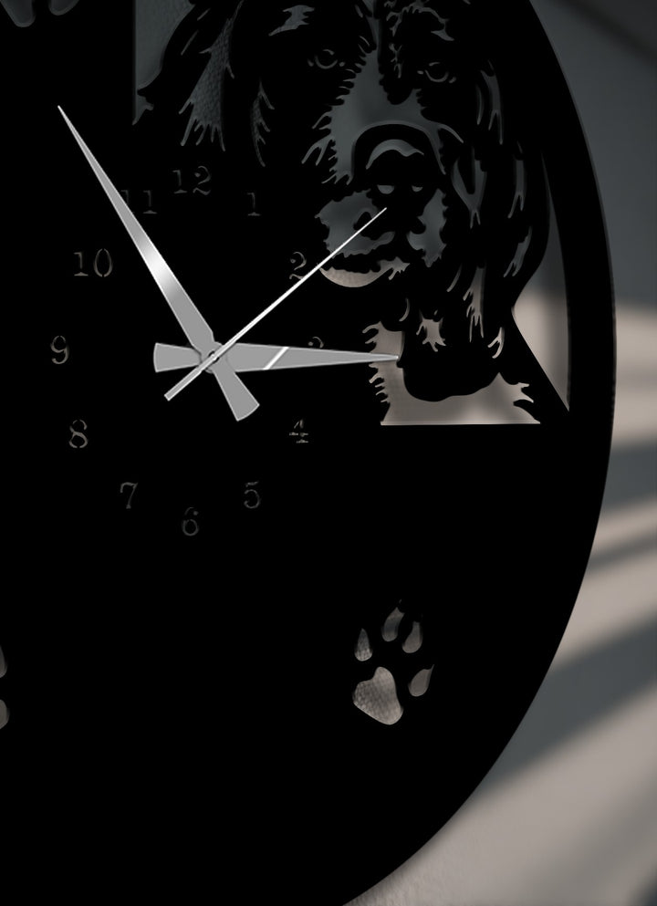 The deeply desaturated decorative metal art wall clock displays a striking black dog silhouette and paw print design with silver hands.