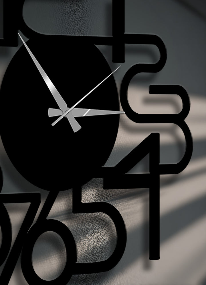 A metal artwork wall clock features desaturated black numbers and hands against a textured grey wall, highlighting its minimalist design.