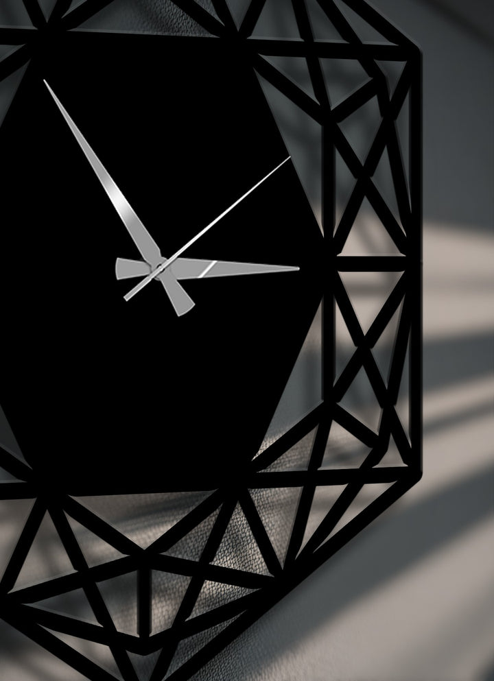 The striking silver clock hands boldly cross the dark hexagonal face of this modern minimalist geometric metal art for wall.