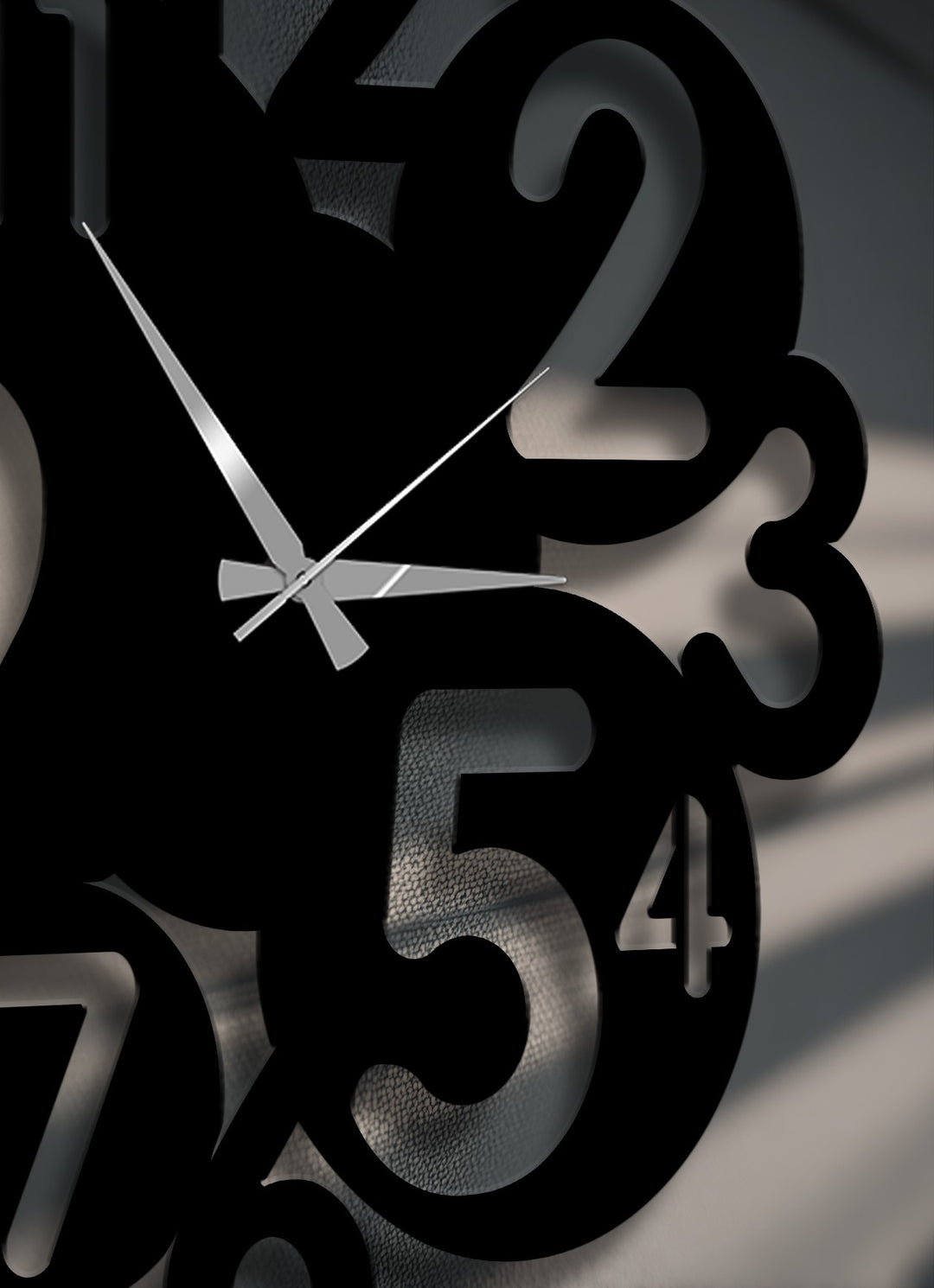 Bold, black, overlapping numbers create a striking modern abstract design on this metal wall decor, featuring sleek silver clock hands.