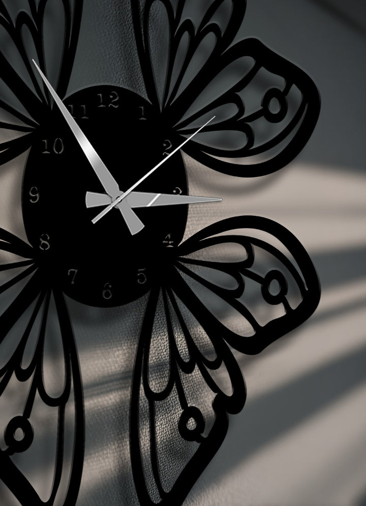 The darkest area highlights the intricate black butterfly wings metal wall clock, a stylish metal art for wall piece with subtle, elegant design.