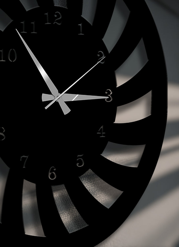 The brightest areas highlight the reflective clock hands and the subtle textures seen through the dynamic spiral cutouts of this unique metal wall art.