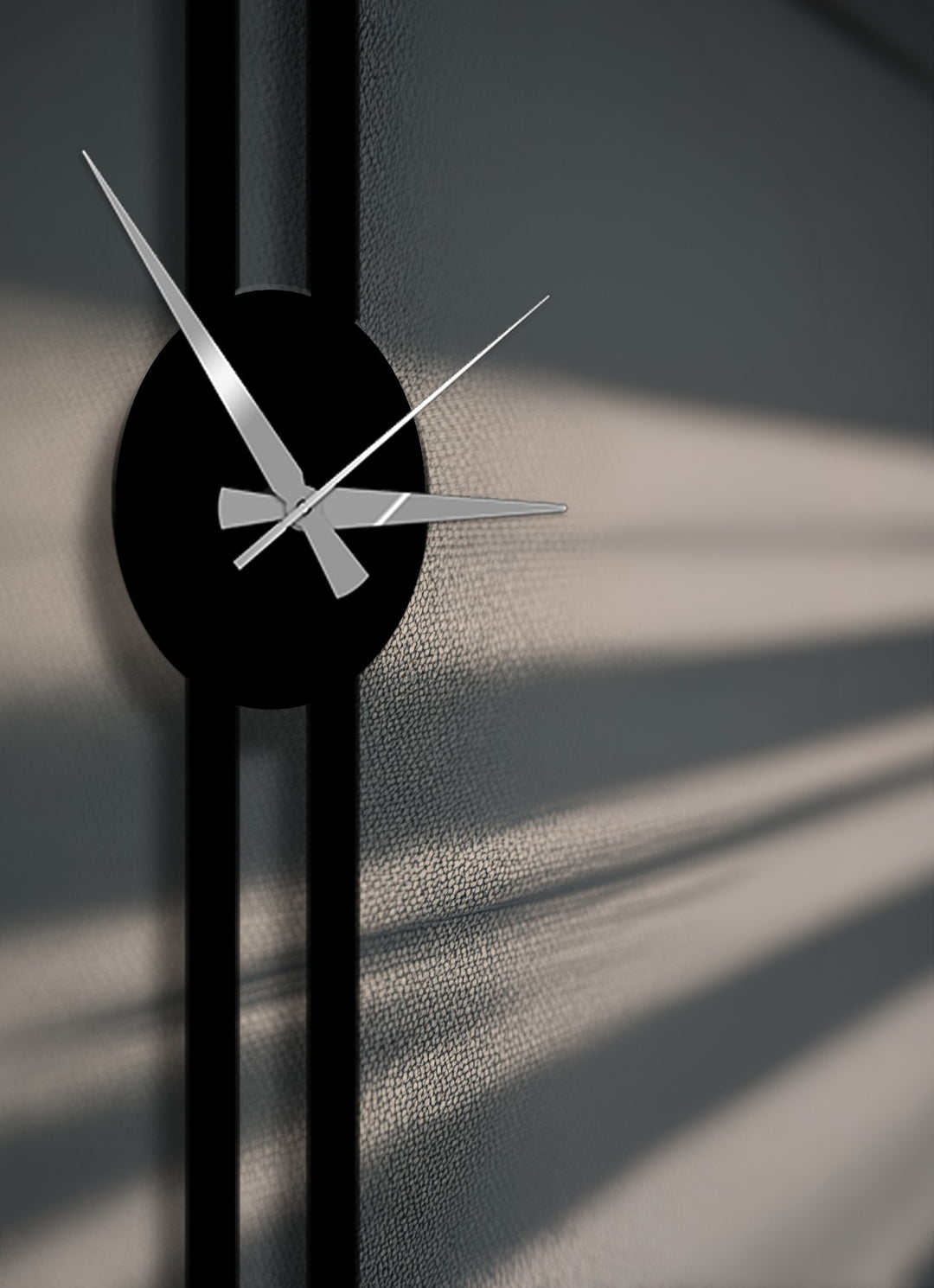 The brightest area distinctly shows the sleek silver hands of the minimalist vertical metal wall clock against the textured modern metal wall decor.