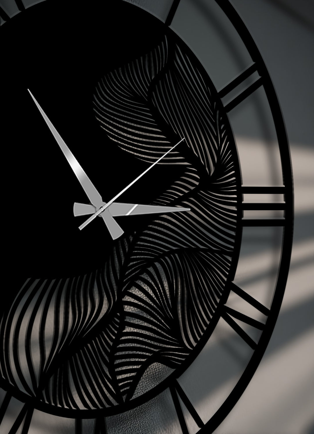The striking decorative metal art clock showcases its bold Roman numeral outer edge and intricate abstract leaf pattern borders.