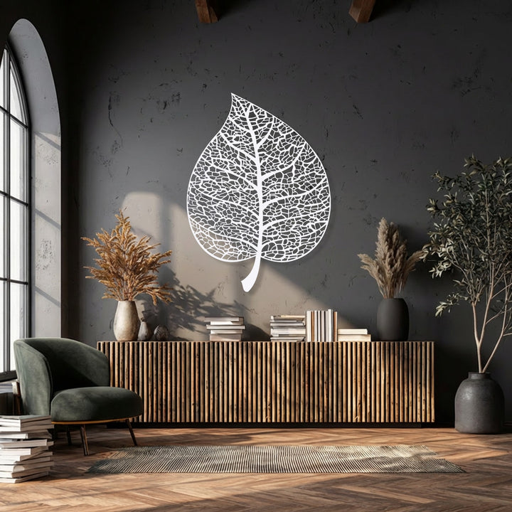 The tranquil mood of a modern, nature-inspired living space is enhanced by an elegant, intricate botanical leaf silhouette decorative metal art piece.