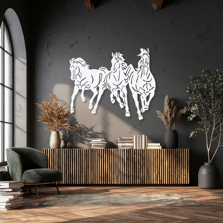 Strong sunlight casts dramatic shadows highlighting the dynamic galloping trio horses decoration wall art on a dark textured wall.