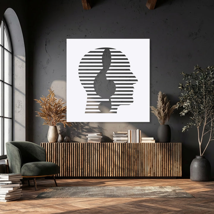 The striking color contrast in this metal wall decor highlights an abstract face with stark white and deep charcoal striped lines against a dark backdrop.