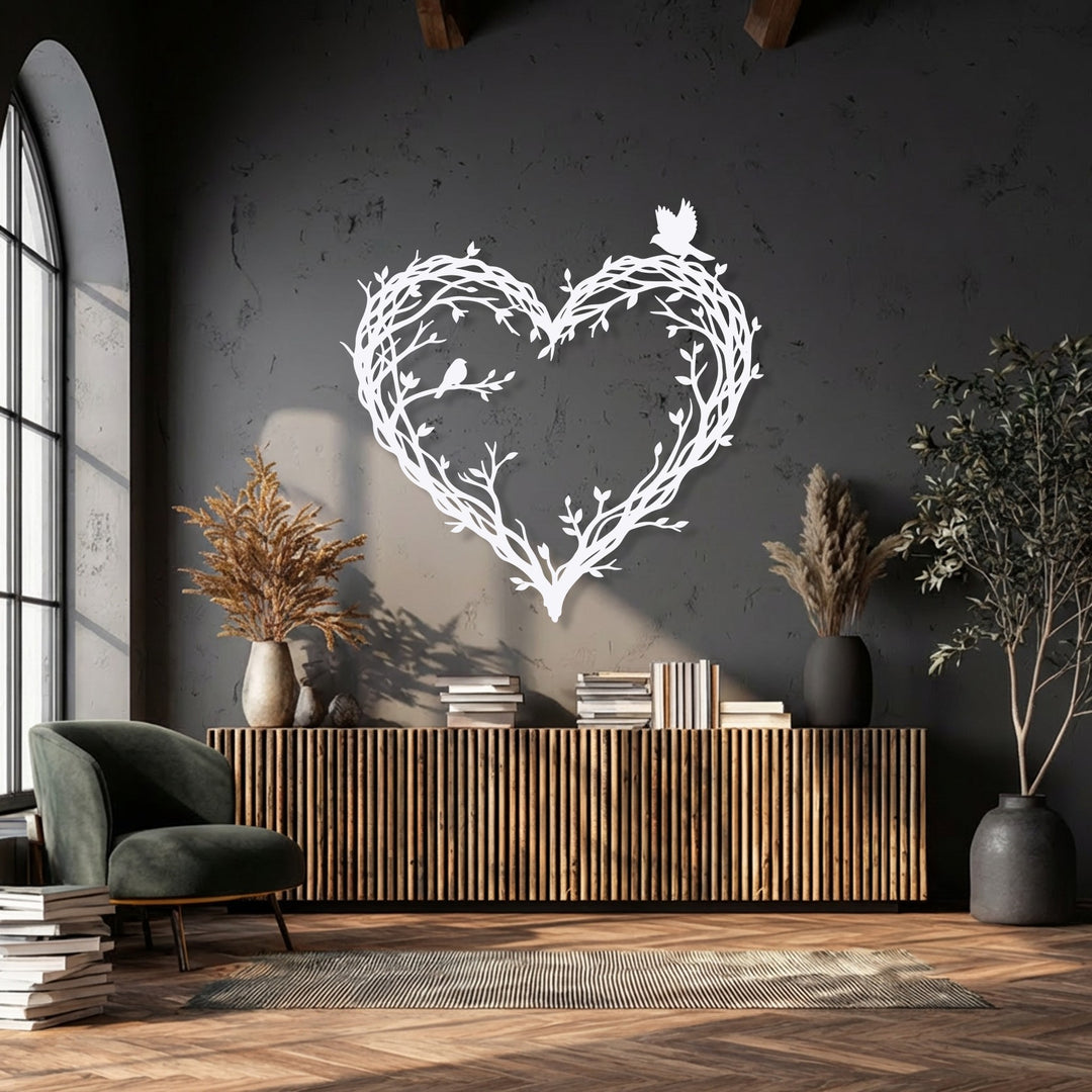 The radiant white bird & branch heart metal wall art, an intricate piece of decoration wall art, glows brightly against the dark textured wall.