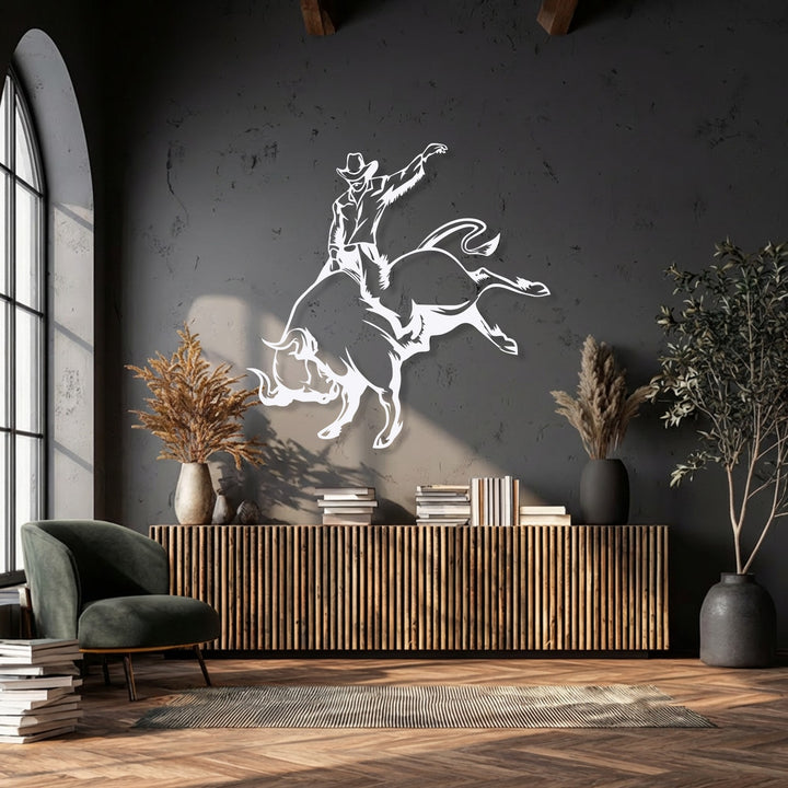 A dark, textured wall serves as a bold backdrop for the unique metal wall art depicting a wild rodeo cowboy bull riding.