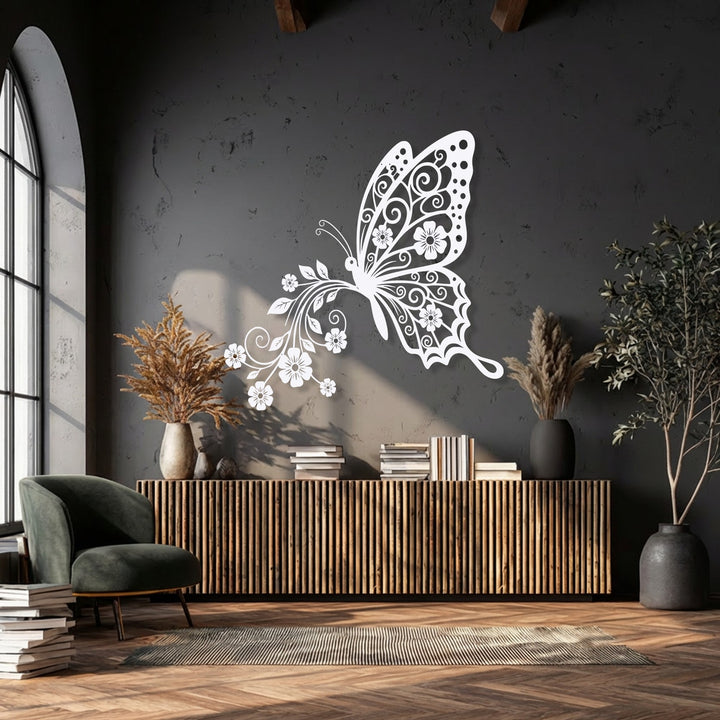 The brightest area highlights the ornate white butterfly with delicate floral wings, a unique metal wall art piece adorning a dark charcoal wall.