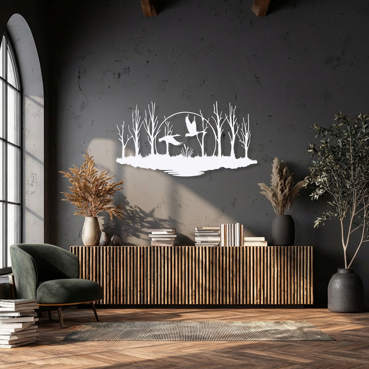The layering effect is prominent in this decorative metal art, with white flying birds and a forest marsh silhouette creating depth against a dark wall.