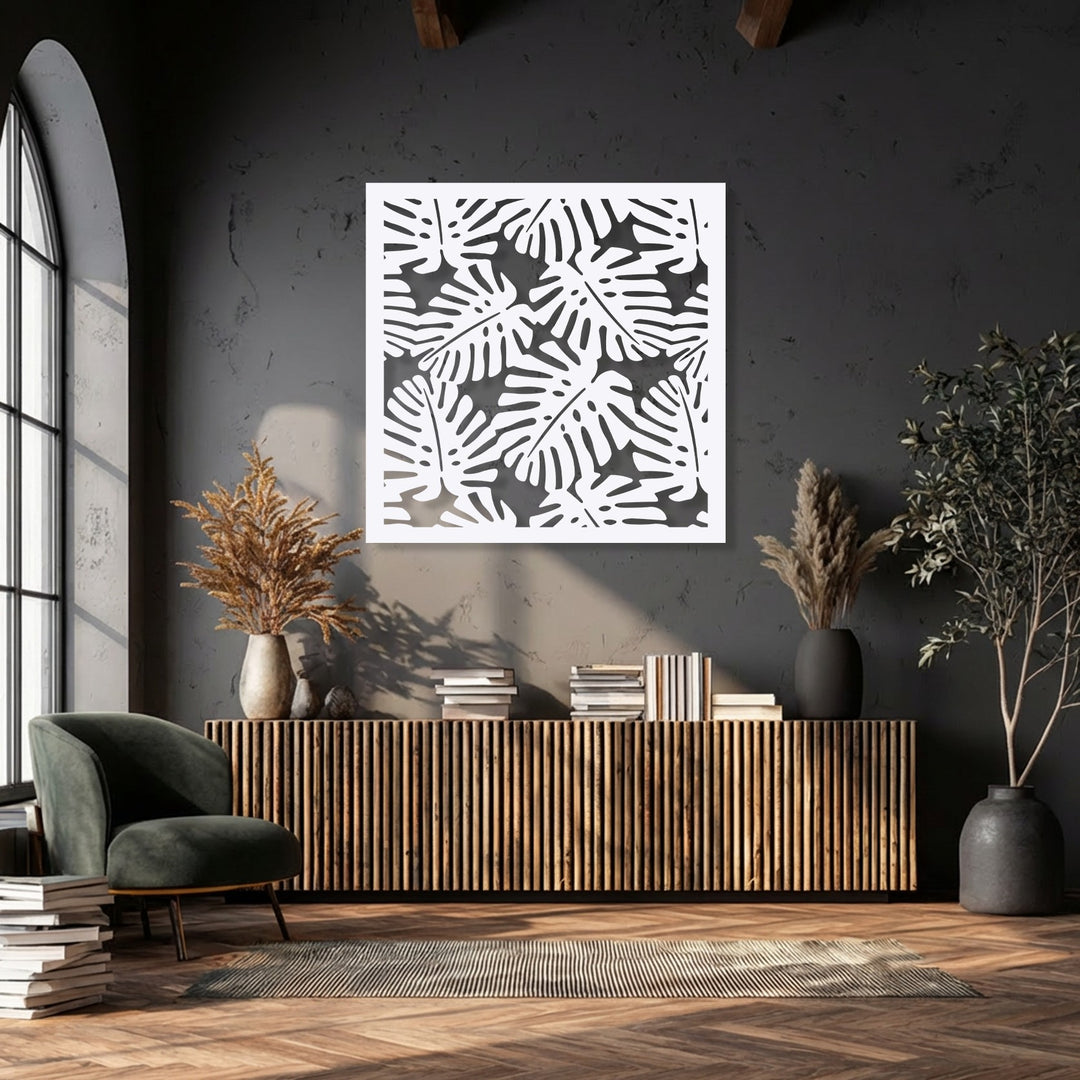 Against a dark, textured wall, the tropical monstera leaf pattern metal artwork adds visual depth, layered above a warm wooden console.