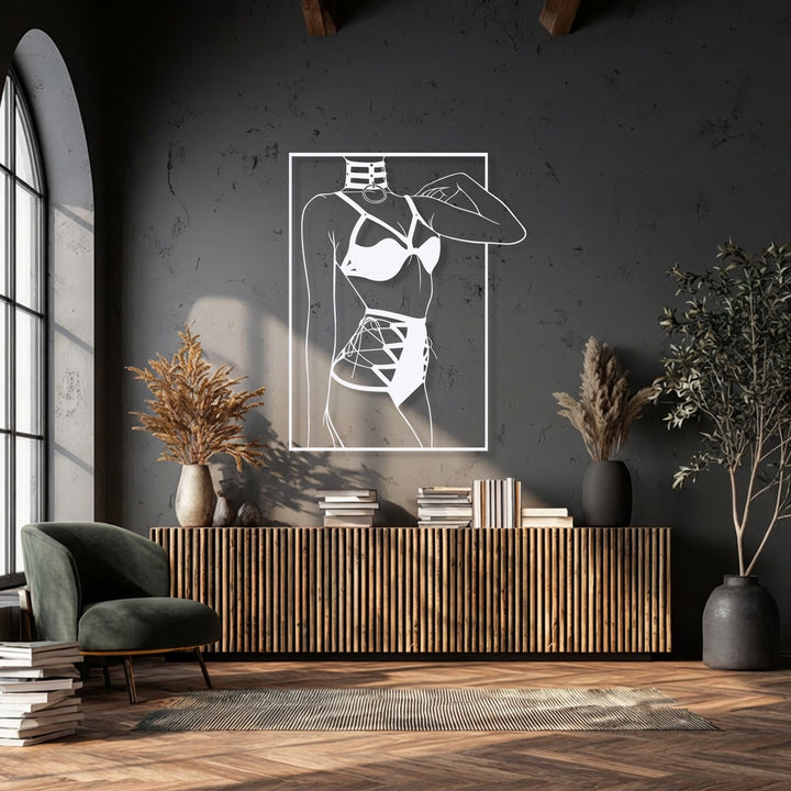 The stillness of the room is accentuated by a striking minimalist female silhouette line art metal artwork on a dark wall.