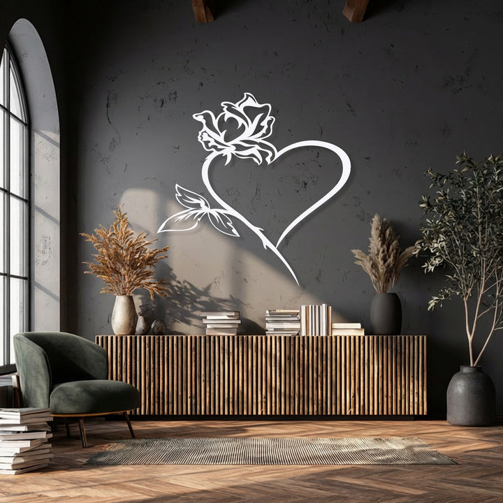 Emphasizing the flowing, natural curves of the rose and heart, this decorative metal art piece brings organic elegance to the dark wall.