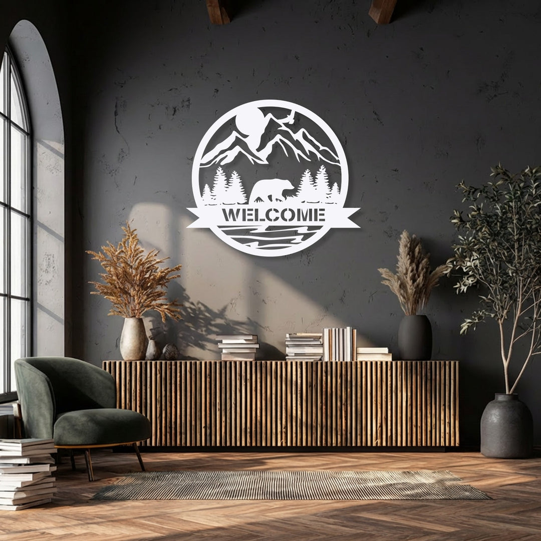 The striking color contrast between the crisp white Mountain Bear Welcome Sign metal artwork and the deep charcoal wall is visually compelling.