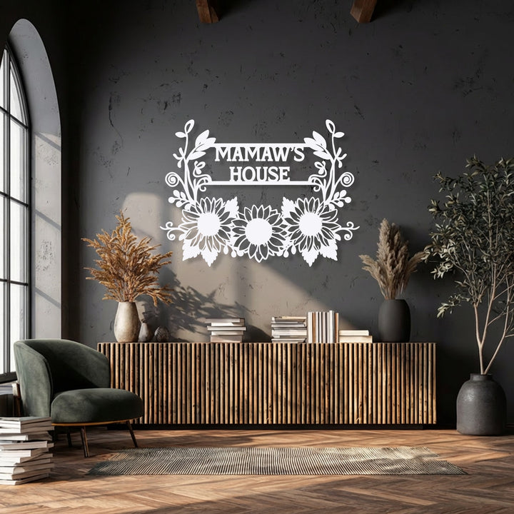 A horizontal, ornate metal wall decor featuring sunflowers and a central rectangular frame, personalized with 'MAMAW'S HOUSE' in a stylish font.