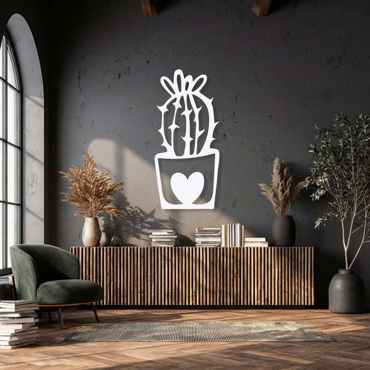 The negative space within the intricate white outlines forms a cute cactus with a heart pot, making it a unique piece of decorative metal art.