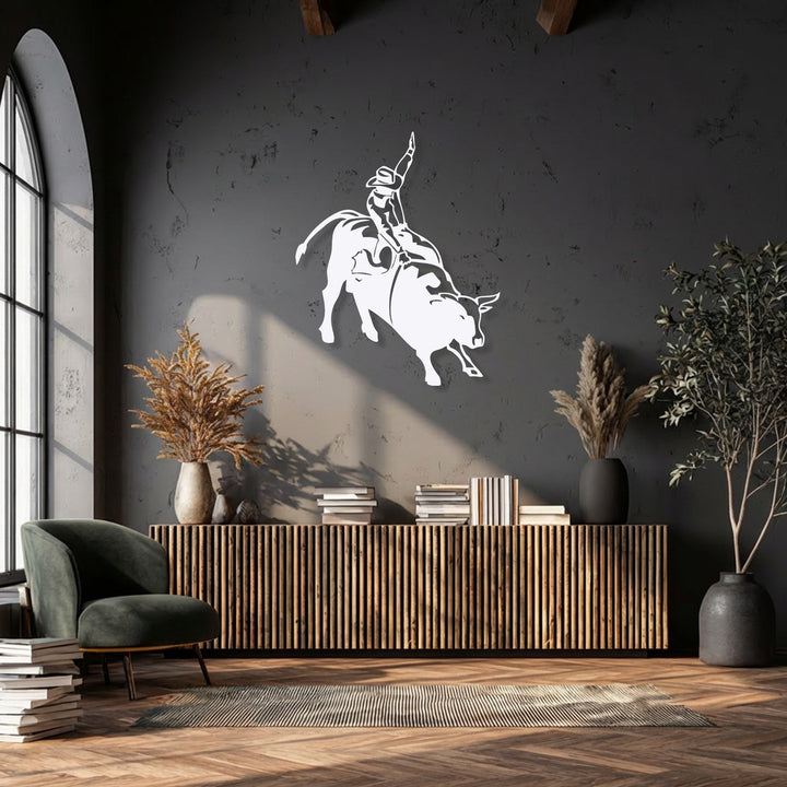 This metal artwork powerfully illustrates the intense, athletic movement of a rodeo cowboy expertly riding a bucking bull.