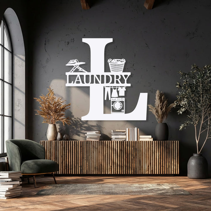 The vivid white personalized laundry room monogram 'L', a unique metal wall art piece displaying an iron, basket, and washer, shines.
