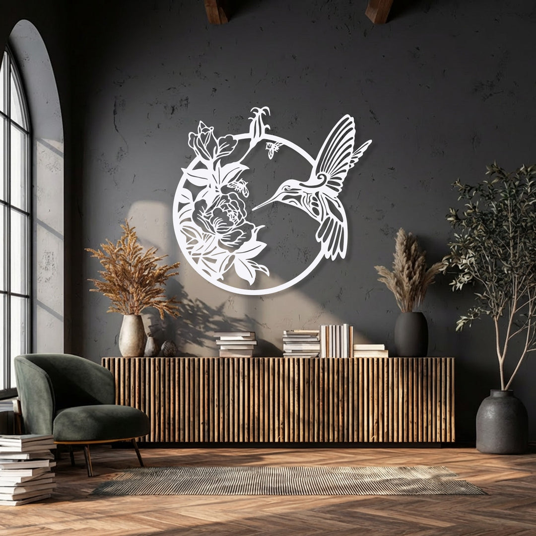 Intense light and shadow define the room's depth, highlighting the elegant hummingbird and floral metal artwork against the dark wall.