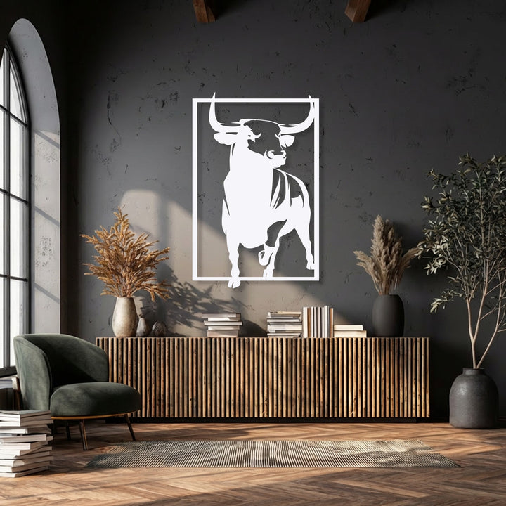 A bold and powerful mood is created by the striking bull decorative metal art on a dark, textured wall.