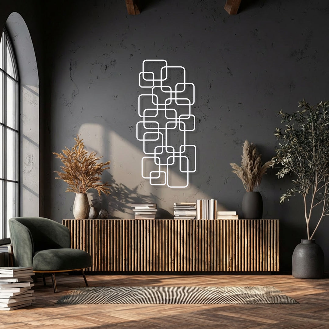 The negative space surrounding the white interlocking geometric pattern creates a striking piece of decorative metal art on a dark charcoal wall.