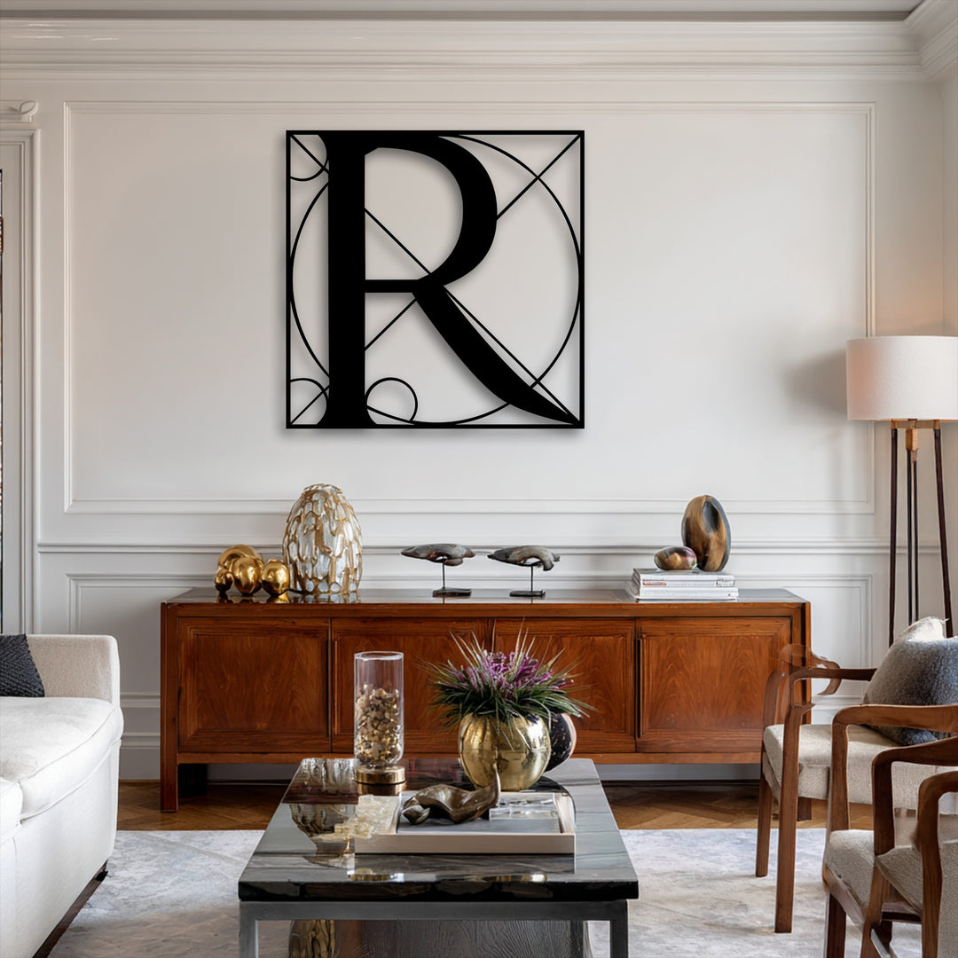 A striking black geometric letter R metal art for wall serves as the focal point above a richly toned wooden console table in a stylish living area.