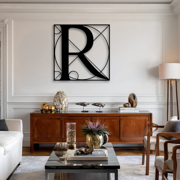 A striking black geometric letter R metal art for wall serves as the focal point above a richly toned wooden console table in a stylish living area.