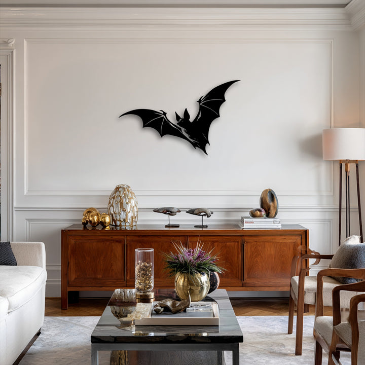 A dark marble coffee table in the foreground holds a gold vase with purple flowers, complementing the gothic flying bat metal wall decor.