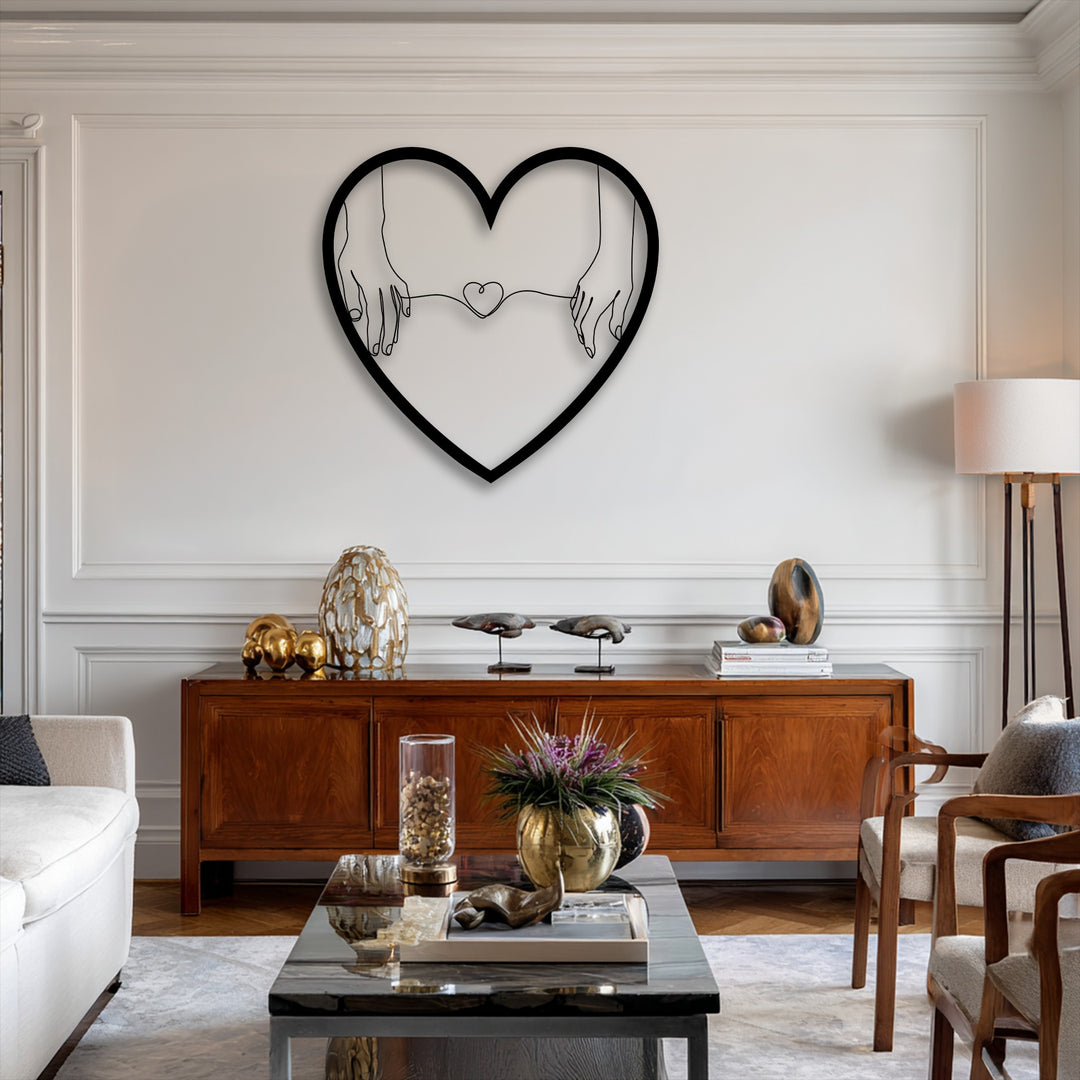 The brightest white wall showcases a minimalist heart-shaped metal wall decor artfully depicting connected hands.