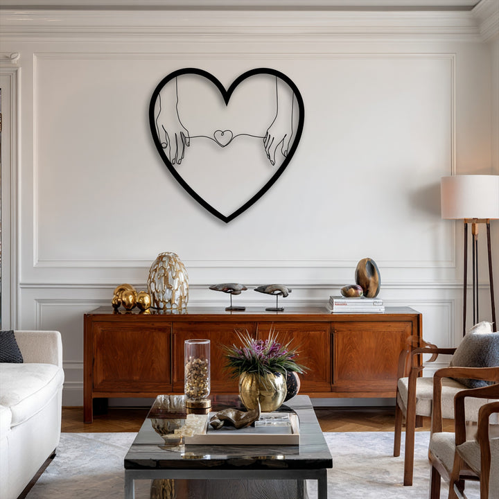 The brightest white wall showcases a minimalist heart-shaped metal wall decor artfully depicting connected hands.