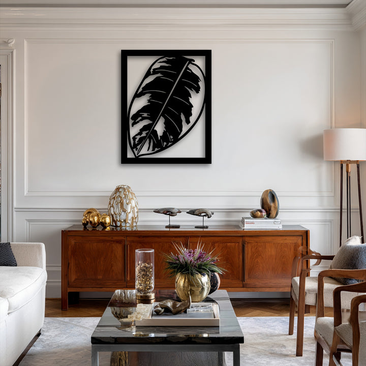 Foreground shows a sleek marble coffee table with a gold vase and flowers, complementing the unique monstera leaf decoration wall art.