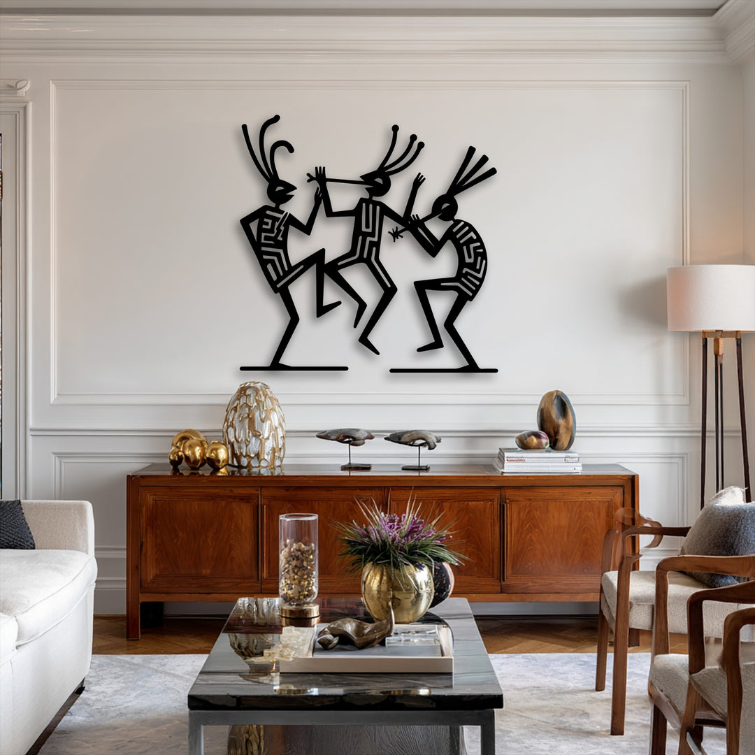 The sharp forms of the tribal dance figures metal artwork cast striking shadows against the brightly lit wall, highlighting their cultural rhythm.