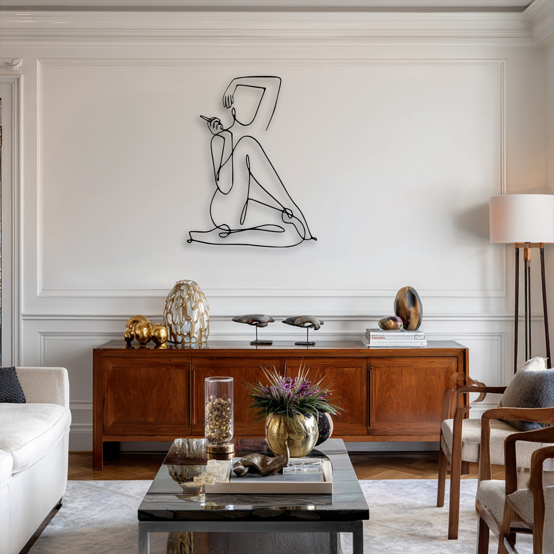 The stark black lines of the minimalist female abstract decoration wall art create a vibrant contrast against the bright white wall, complemented by rich wooden furniture.