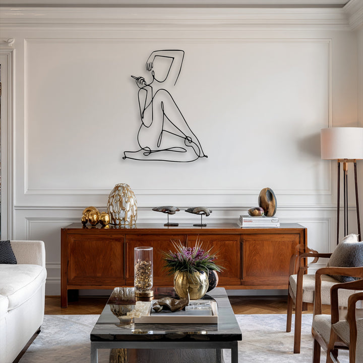 The stark black lines of the minimalist female abstract decoration wall art create a vibrant contrast against the bright white wall, complemented by rich wooden furniture.
