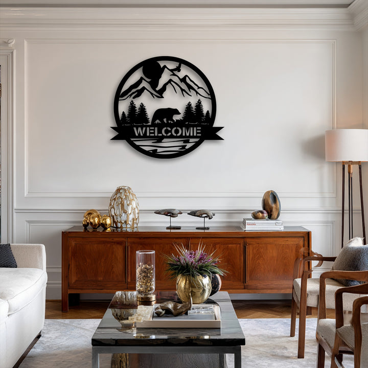 The unique metal wall art realistically details a black silhouette of a bear walking through a detailed mountain forest scene with a 'WELCOME' banner.
