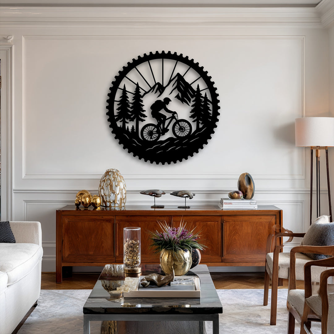 Visual rhythm emanates from the cog-shaped metal artwork, with a cyclist traversing a flowing mountain trail amid rhythmic pine silhouettes.