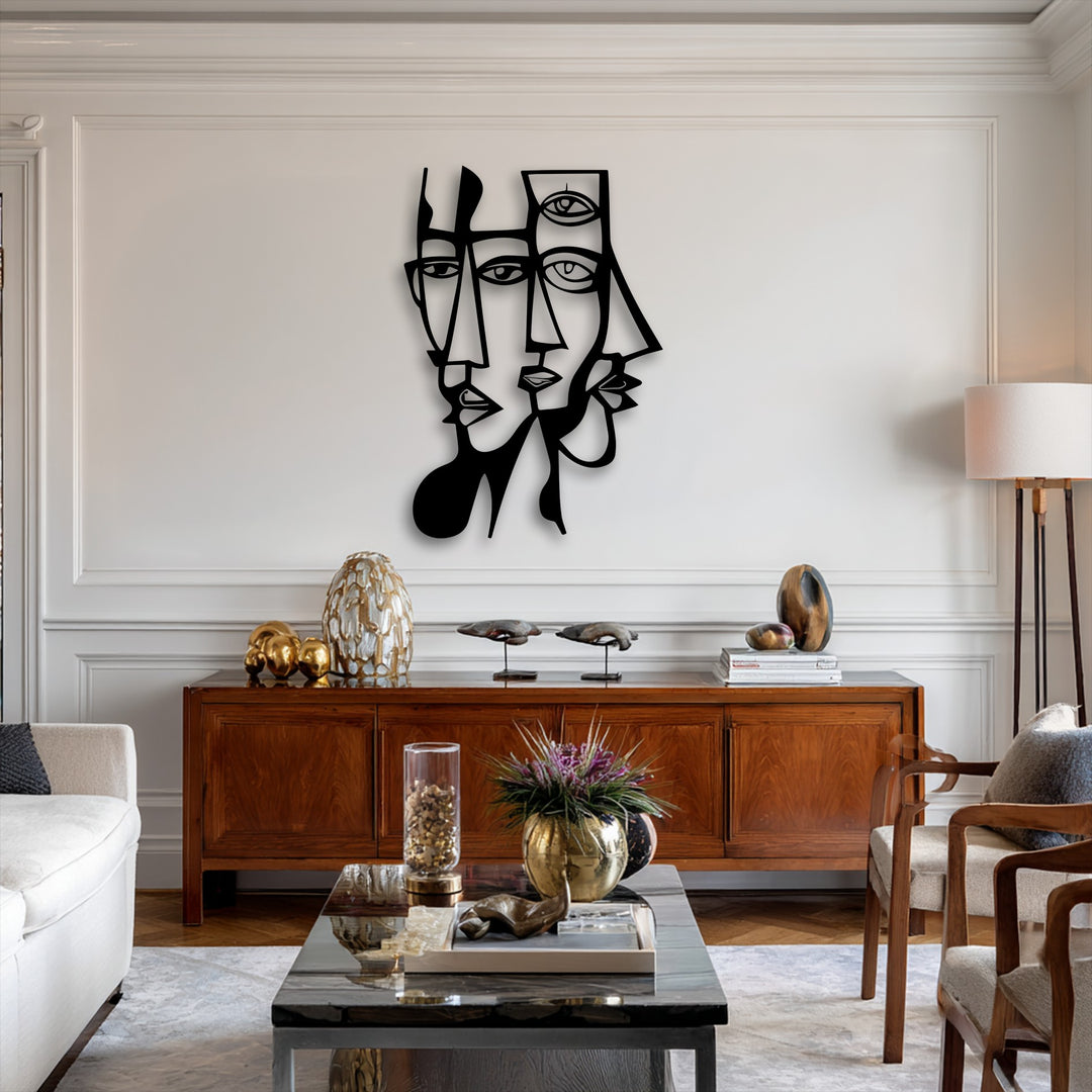 The stark black and white contrast of the abstract dual faces metal artwork pops against the subtly saturated, warm-toned living space.