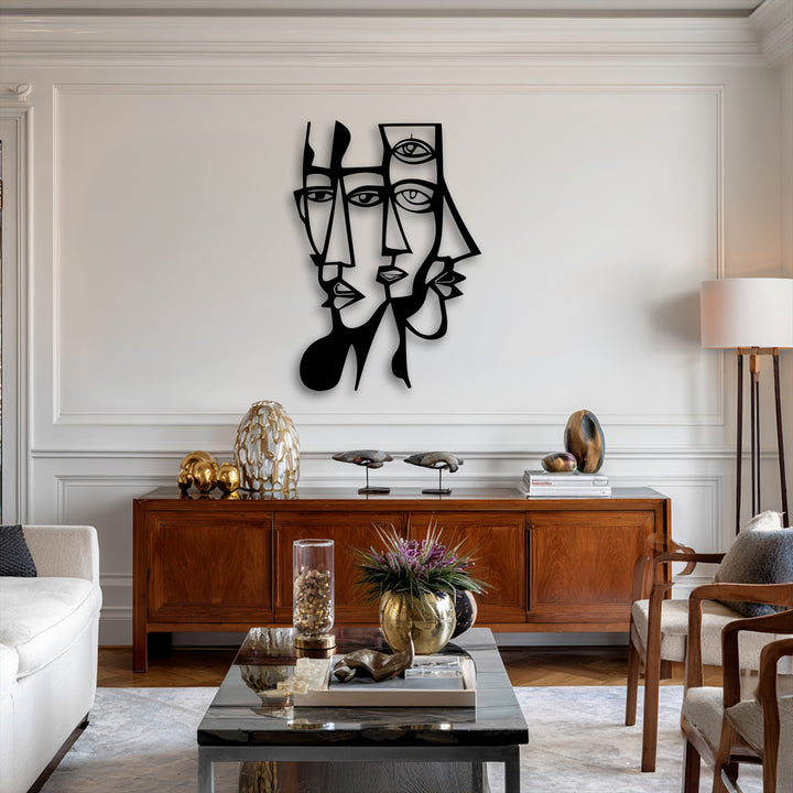 The stark black and white contrast of the abstract dual faces metal artwork pops against the subtly saturated, warm-toned living space.