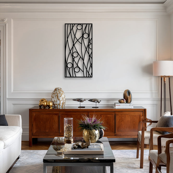 The warm color temperature of the room beautifully highlights the striking black abstract linear geometry metal wall decor on the creamy white wall.