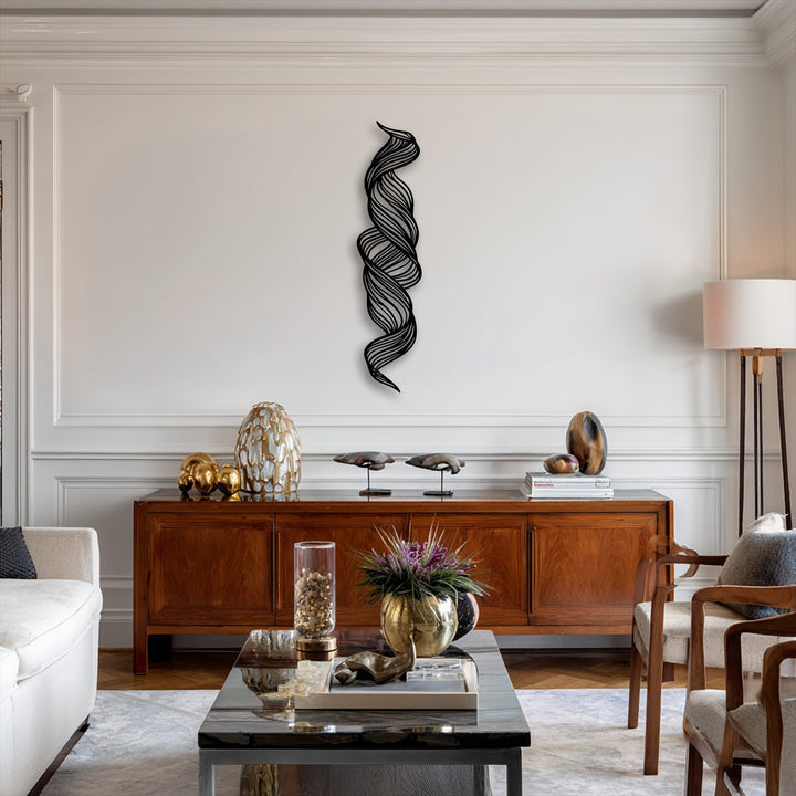 The background is a pristine white wall with classic molding, elegantly contrasting the central abstract twisted flow metal art for wall.