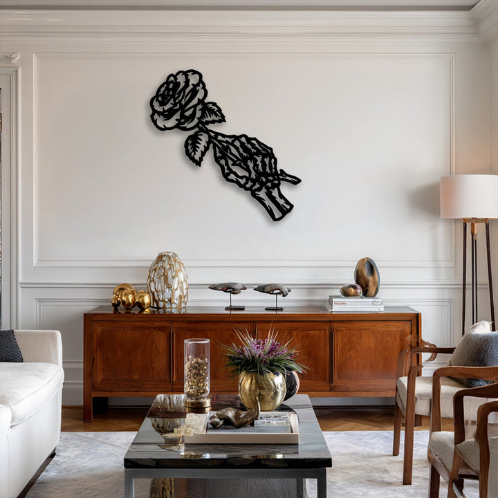 The elegant stillness of a gothic floral metal wall decor featuring a fading rose held by a skeleton hand graces a pristine white wall.
