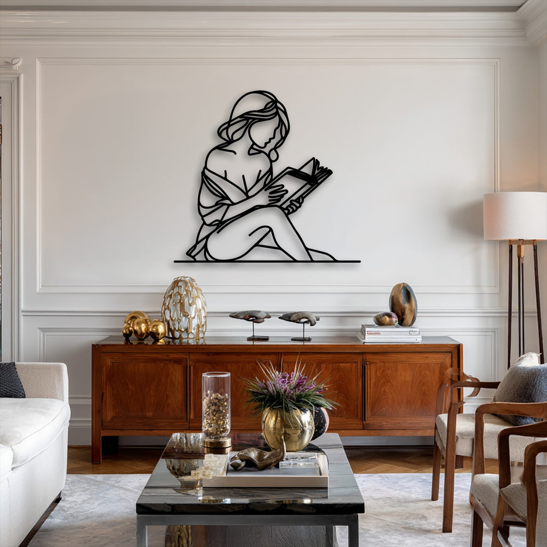 A striking black minimalist silhouette of a serene woman reading a book forms an elegant piece of decoration wall art.
